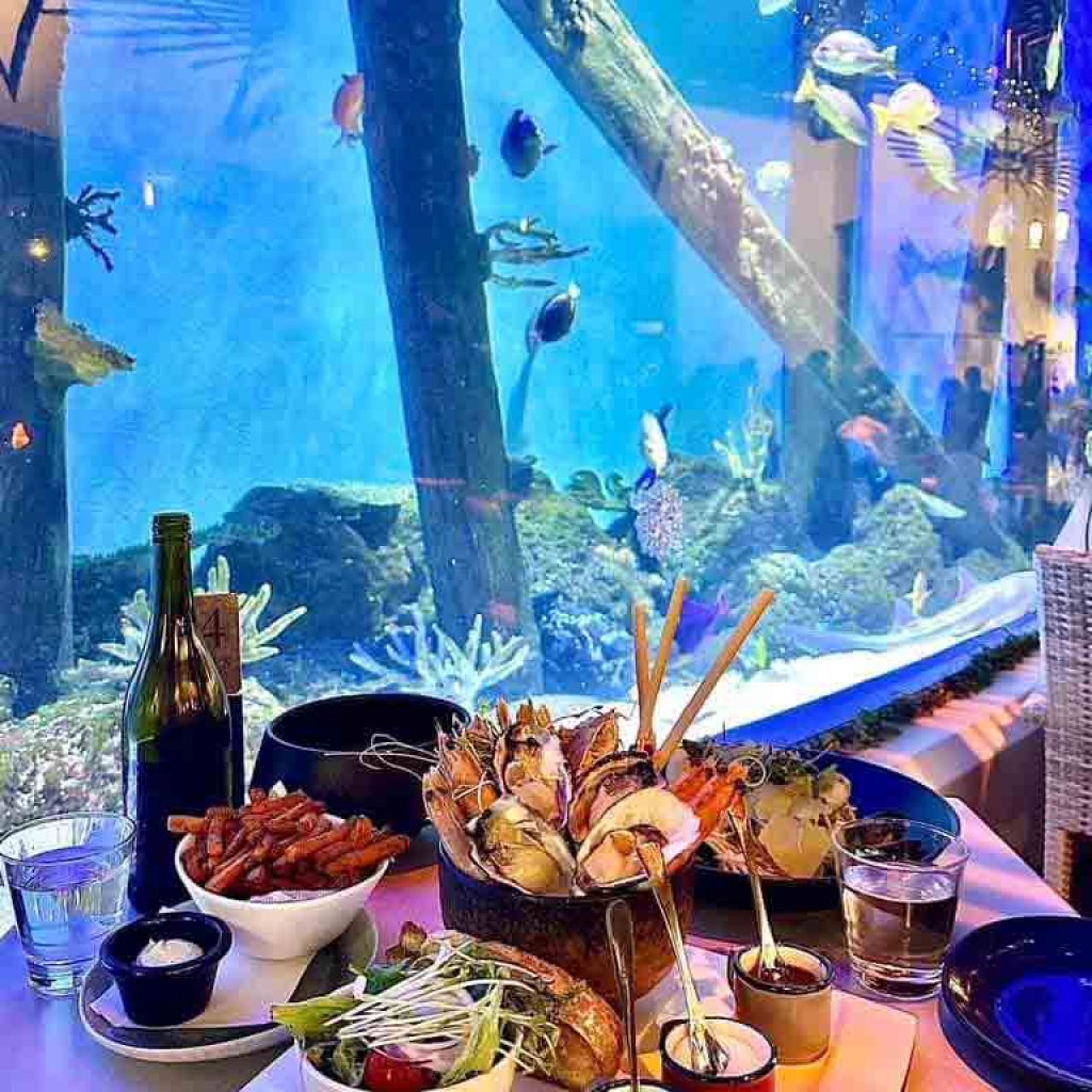 Delicious Food On The Table And Aquarium Background